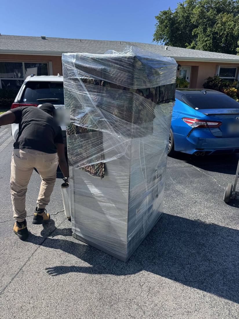 Refrigerator wrapped in blankets and plastic, ready to load