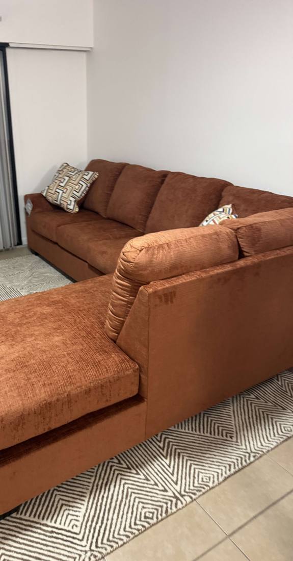 Rust-colored sectional sofa placed in a living room