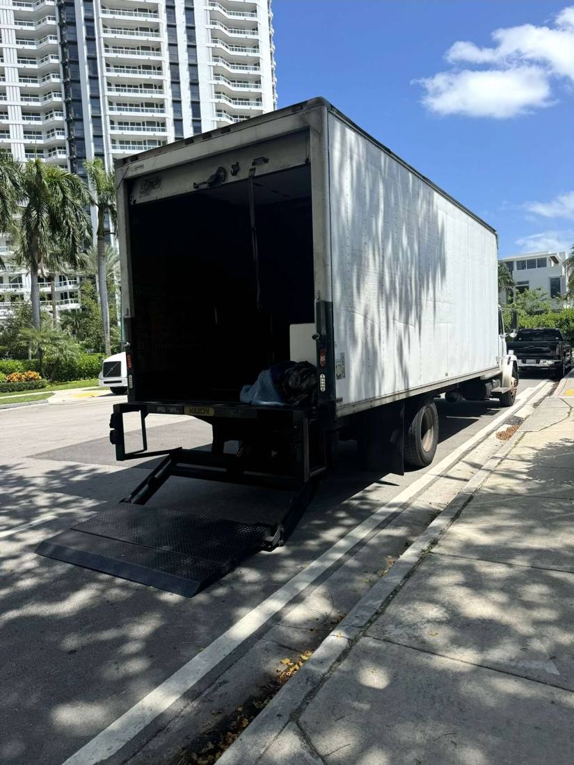24-foot box truck with liftgate lowered outside a high-rise